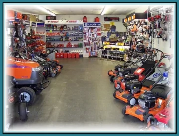The company's showroom floor: orange mowers on a concrete floor with a back wall of parts, chains and accessories